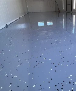 Detailní pohled na novou epoxidovou podlahu s barevným dekorativním vsypem v průmyslovém objektu