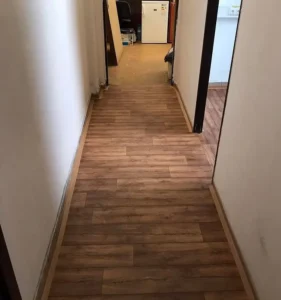 Dlouhá chodba s položeným zátěžovým PVC Ambient v dekoru dřeva, realizace pro Veolia Ostrava.