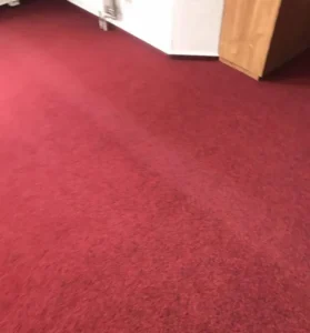 Precizní detail dořezu červeného koberce u dveří