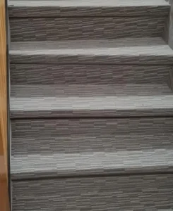 Detailní pohled na vodorovné linie schodiště obloženého krytinou Flotex – mistrovské dílo od virtuózů v pokládce atypických povrchů pro Viva Floors Ostrava.