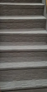 Detailní obklad schodů krytinou Flotex s moderním lineárním vzorem – profesionální montáž od expertů na textilní podlahoviny.