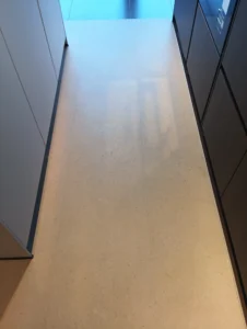 Detail položeného vinylu BerryAlloc pod tmavou kuchyňskou linkou, podlahářství Ostrava.