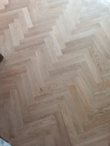 Detail vybroušených dřevěných parket připravených k lakování – profesionální příprava od podlahářů z Ostravy.