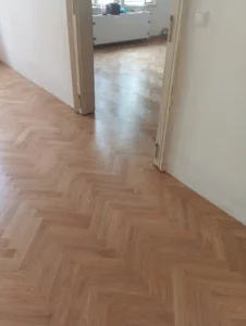 Detailní napojení vybroušených parket v průchodu mezi pokoji – práce, kterou zajišťují specialisté na podlahy.