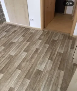 Finální pokládka PVC Ambient v dekoru dřeva u vstupu do místnosti, realizace Ostrava.