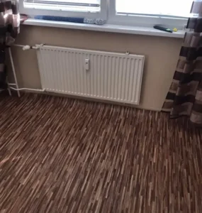 Detail pokládky PVC podlahy Ambient v dekoru dřeva v bytovém interiéru, realizace Ostrava.