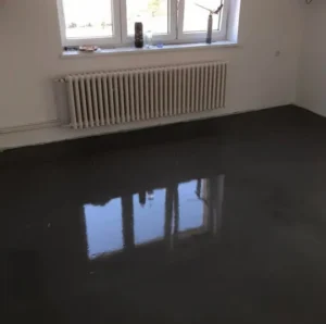 Profesionální broušení betonového podkladu podlahovou bruskou před nivelací.