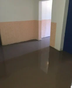 Čerstvě vylitá samonivelační stěrka na chodbě s broskvovou výmalbou, realizace Ostrava.