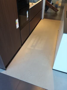 Detail položeného vinylu BerryAlloc pod tmavou kuchyňskou linkou, podlahářství Ostrava.