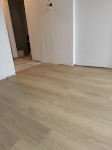 Detail pokládky lepeného vinylu BerryAlloc Zenn 55 v přechodu mezi místnostmi v bytě Ostrava-Výškovice