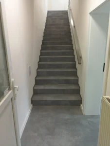 Pohled z chodby na schodiště obložené zátěžovým vinylem Gerflor v komerčních prostorách v Ostravě